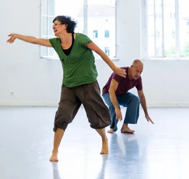 Zwei Teilnehmer:innen in ausdrucksstarker Bewegung